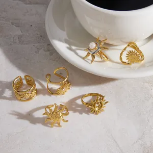 Detailansicht goldener Edelstahlringe mit Sonnen- und Mondstein-Motiv auf Tasse