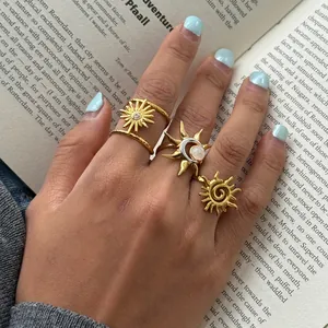 Detailaufnahme von böhmischen Goldringen mit Sonne und Mond auf einer Hand über einem Buch