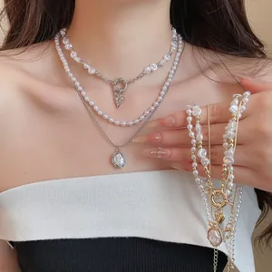 Detailopname van vintage meerlaagse parelketting met hartvormige hanger op model