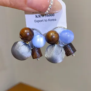 Stijlvolle stoffen bal oorbellen met houten kralen en lichtblauwe accenten