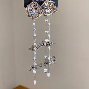Detailansicht der silbernen Metallblumen-Ohrhänger mit eleganten Glasperlen-Quasten
