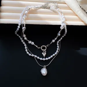 Detailweergave van Franse vintage meerlaagse parelketting met hart- en ovale hangers