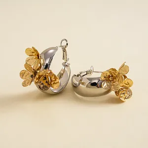 Detaillierte Ansicht von Vintage-Ohrringen aus Silbermetall mit goldenen Blumenakzenten