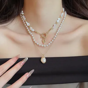 Close-up detail van een Franse retro meerlaagse parelketting met een gouden harthanger