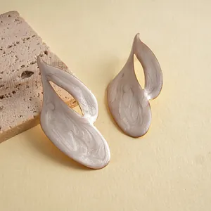 Makroansicht unregelmäßiger geometrischer Ohrringe mit Perlglanz-Emaille-Finish.