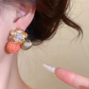 Gedetailleerd overzicht van elegante zirkoon bloemoorbellen met stoffen bolhangers