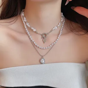 Detailopname van een Franse vintage meerlaagse parelketting met hartjeshanger.