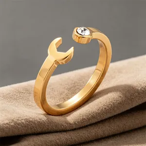 Close-up of creative gold wrench-shaped stainless steel ring with crystal inlay