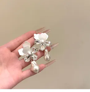 Detailweergave van Franse retro oorbellen met bloemen en witte barokke parels
