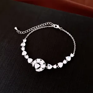 Détail d'un bracelet plaqué or 18 carats avec pendentifs lune et cœur en zircons cubiques