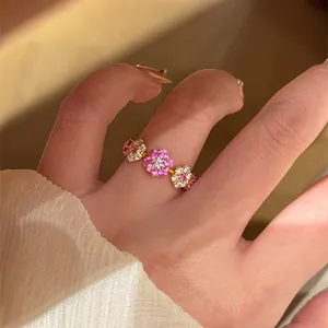 Gedetailleerd overzicht van een 14k vergulde open ring met roze zirkoonbloemen