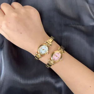 Primo piano di due piccoli orologi tondi dorati in stile vintage francese su un polso