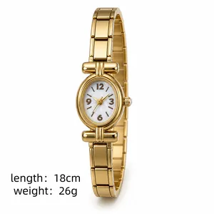 Dettaglio di un orologio vintage dorato da donna con quadrante ovale e cinturino in metallo.