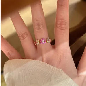 Detailopname van 14k vergulde bloemring met sprankelende roze en witte zirkonia steentjes