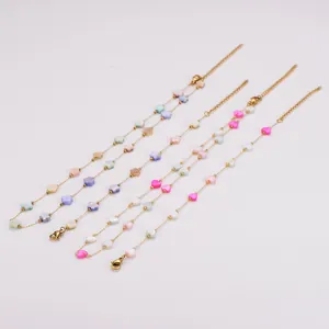 Detailed view of colorful shell heart and flower charms on gold stainless steel chains.