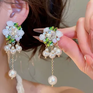Nahaufnahme von Vintage-Blumenohrringen mit funkelnden Kristallen und eleganten weißen Perlen