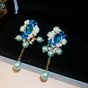 Detaillierte Ansicht von Vintage-Palast-Ohrringen mit blauen Kristallen und Perlen.