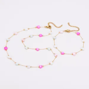 Detail view of gold-plated stainless steel jewelry set with pink shell hearts