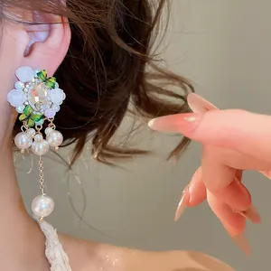 Detailaufnahme von Vintage-Blumen-Kristallohrringen mit eleganten Perlenanhängern