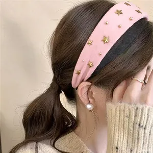 Detail view of pink vintage fabric headband decorated with gold stars and studs