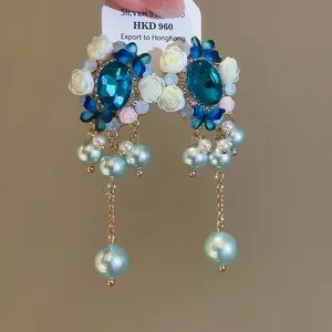 Detailansicht der floralen Ohrringe im Vintage-Stil mit blauen Kristallen und Perlen.