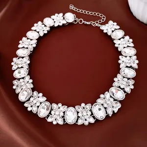 Detailed close-up of a luxury silver necklace featuring oval crystals and floral motifs on silk