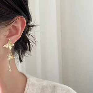 Nahaufnahme von eleganten goldenen Schmetterlings-Ohrringen mit Glitzersteinen