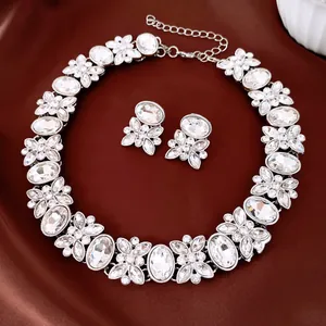 Elegant oval crystal floral necklace and earrings jewelry set on brown satin background