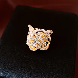 Détail en gros plan d'une bague ovale dorée ornée de pavés en zircone étincelants.