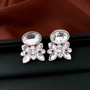 Close-up of silver-tone flower stud earrings with oval and marquise clear crystals.
