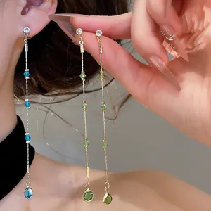 Detail of long blue and green crystal tassel earrings with elegant water drop pendants.
