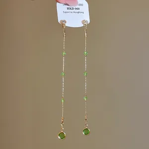 Close-up detail showing the elegant long tassel design with green crystal beads