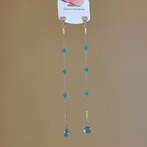Elegant silver tassel earrings featuring blue crystal beads and a teardrop pendant.