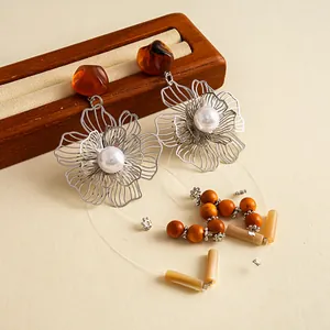 Nahaufnahme von Vintage-Blumenohrringen aus Silber mit Harzperlen und Quastendetails.
