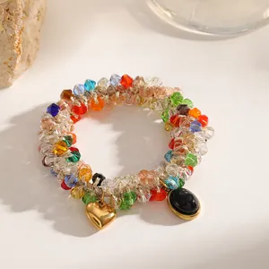 Detailed macro shot of a multi-color beaded elastic bracelet with a gold heart charm.