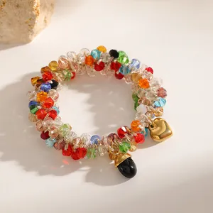Close-up view of a colorful beaded elastic bracelet featuring gold heart and black charms.