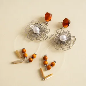 Detailansicht der Vintage-Ohrringe mit hohlen Metallblumen, Harzperlen und Perlen