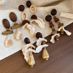 Detailed view of handmade ethnic earrings with wooden beads and shell-like drops