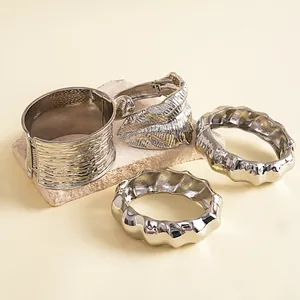 Detailopname van zilveren gestructureerde armbanden met een bladvormig design.