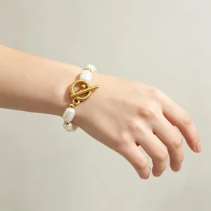Nahaufnahme eines luxuriösen Barock-Perlenarmbands mit goldenem OT-Verschluss am Handgelenk