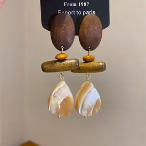 Detail shot of vintage wood and shell waterdrop earrings in neo-Chinese style