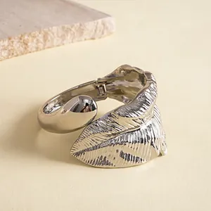 Gedetailleerde weergave van zilveren metalen bladarmband met getextureerde afwerking