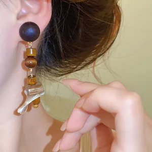 Close-up detail of vintage ethnic style wood and shell drop earrings for women fashion