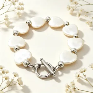 Detailansicht eines Herz-Muschel-Armbands mit elegantem silbernem OT-Verschluss-Design.