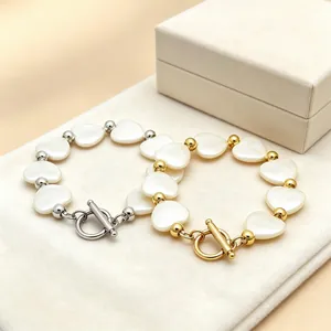 Detailansicht der goldenen und silbernen Herz-Muschel-Armbänder mit OT-Verschluss auf Samt.