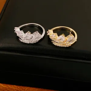 Detailweergave van gouden en zilveren open ringen met fonkelende druppelvormige zirkonia.