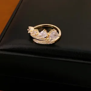 Close-up van een gouden ring met sprankelende peervormige zirkonia's en verfijnde details.