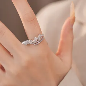 Gedetailleerd beeld van een elegante open ring met fonkelende druppelvormige zirkonia's.
