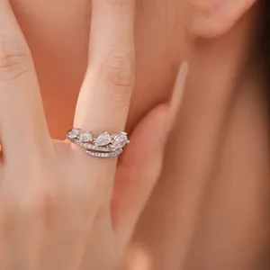 Gedetailleerde close-up van een elegante zilveren zirkoon druppel open ring aan een vinger