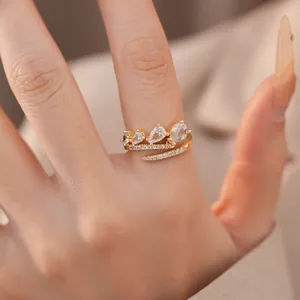 Gedetailleerd macro-aanzicht van een gouden verstelbare ring met peervormige witte zirkonia